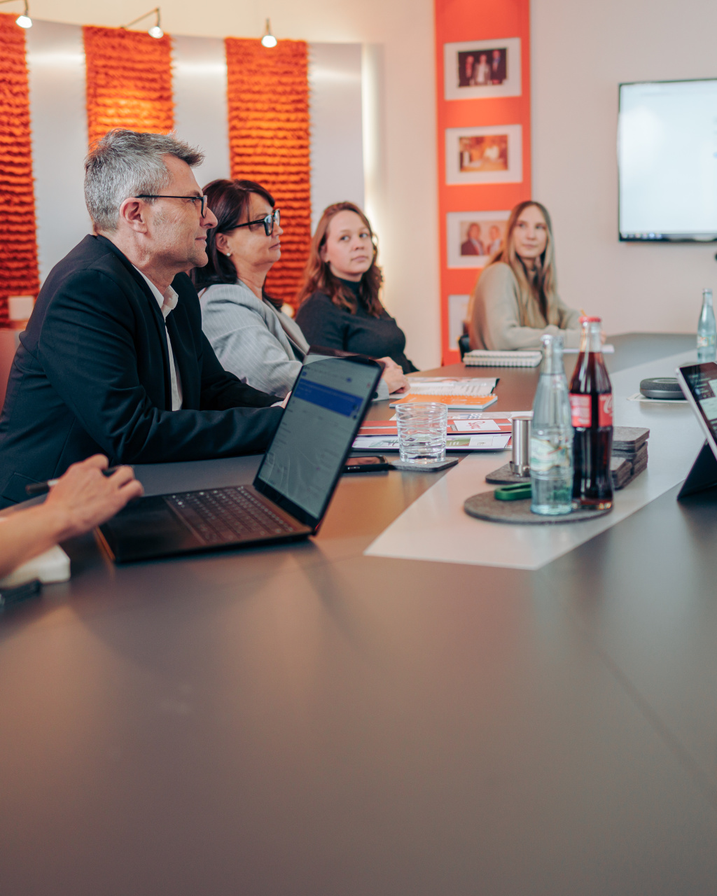 Personen unterhalten sich gemeinsam bei einem Marketing-Meeting in einem Besprechungsraum.